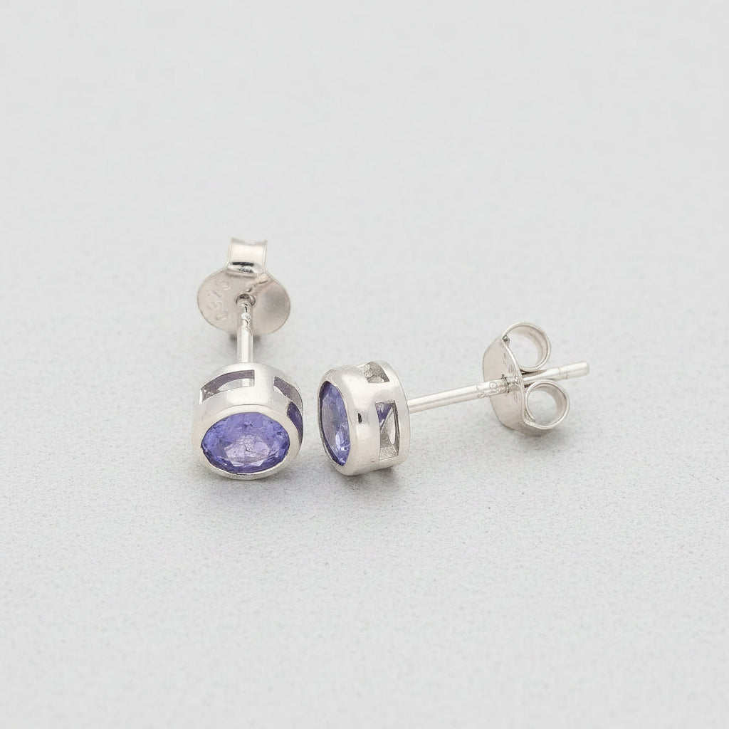 Silver earrings with purple gemstones on a white background